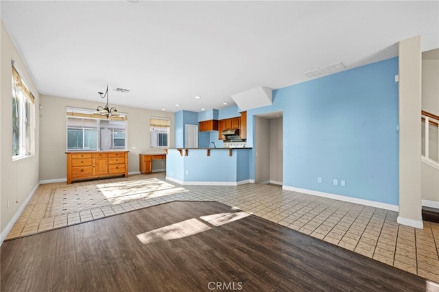 unfurnished living room featuring light tile patterned floors and a notable chandelier