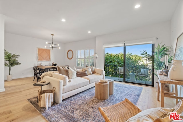 living room featuring light wood-type flooring and an inviting chandelier