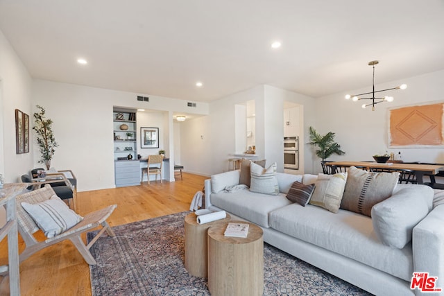 living room with hardwood / wood-style floors and a notable chandelier