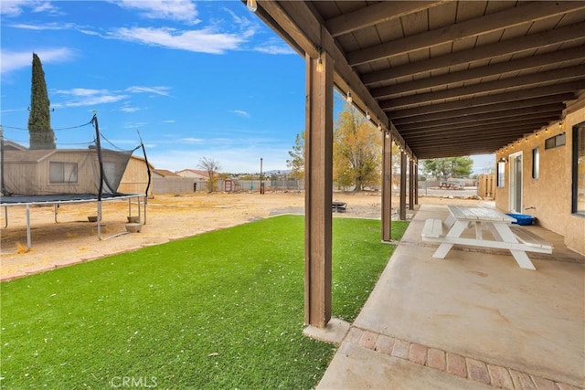 view of yard featuring a patio and a trampoline