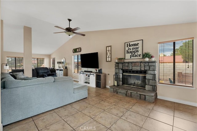 tiled living room with plenty of natural light, ceiling fan, a stone fireplace, and vaulted ceiling