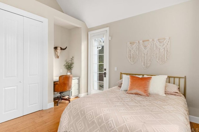 bedroom with wood-type flooring, a closet, and lofted ceiling