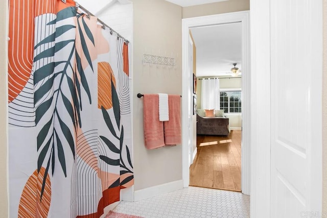 bathroom with a shower with shower curtain, hardwood / wood-style floors, and ceiling fan