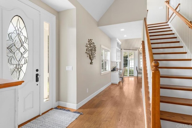 entryway featuring light wood-type flooring and vaulted ceiling