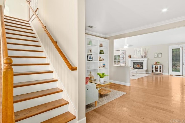 stairway featuring crown molding and hardwood / wood-style floors