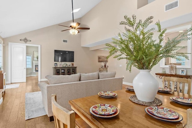 dining room featuring ceiling fan, light hardwood / wood-style floors, and high vaulted ceiling