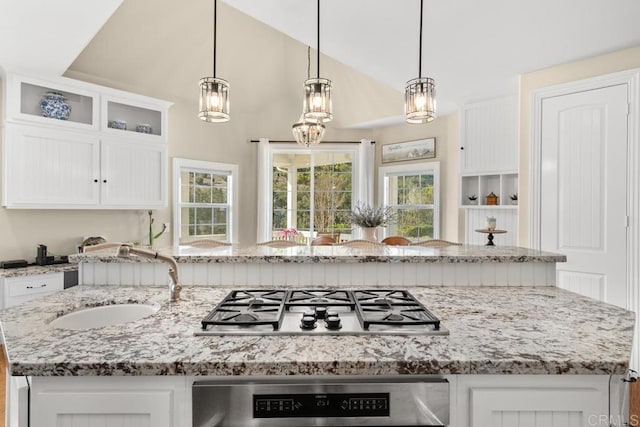 kitchen featuring hanging light fixtures, a kitchen island with sink, stainless steel gas cooktop, and sink