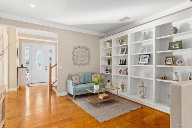 living area featuring light wood-type flooring and crown molding