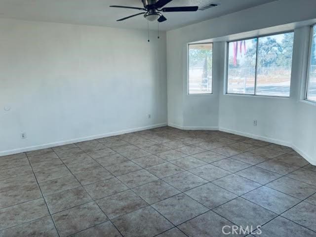 unfurnished room with ceiling fan and plenty of natural light