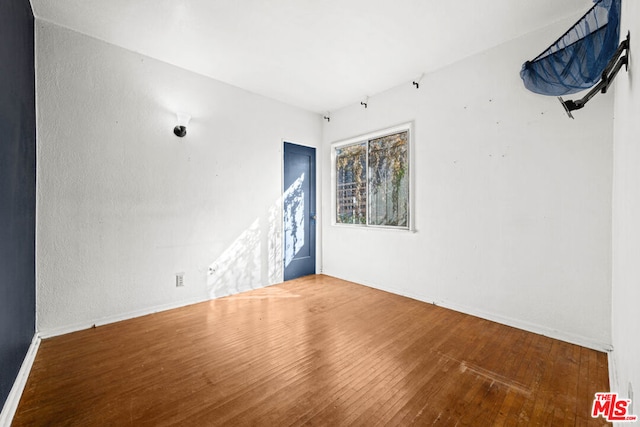 spare room featuring wood-type flooring