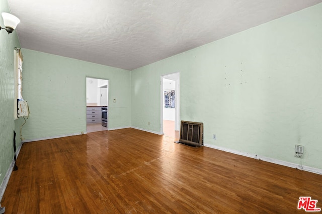 empty room featuring a textured ceiling and hardwood / wood-style flooring