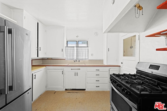 kitchen featuring extractor fan, appliances with stainless steel finishes, white cabinetry, and sink