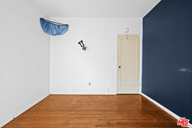 spare room featuring wood-type flooring