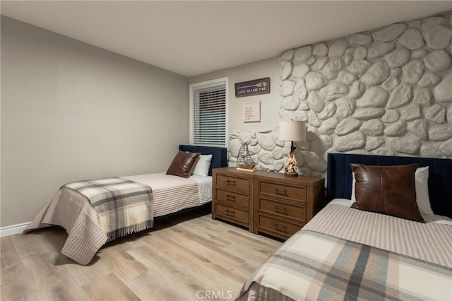 bedroom featuring a fireplace and light hardwood / wood-style flooring