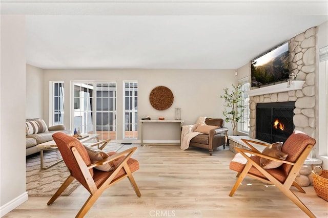 sitting room featuring a wealth of natural light, a fireplace, and light hardwood / wood-style floors