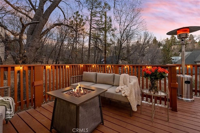 deck at dusk with an outdoor living space with a fire pit