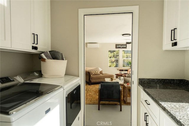 laundry room featuring washer and dryer and cabinets