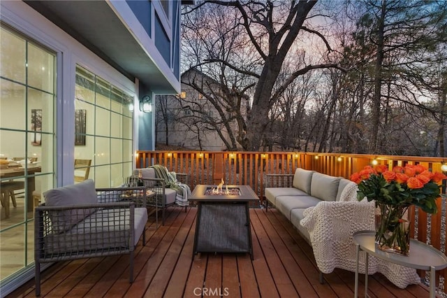 deck at dusk featuring an outdoor living space with a fire pit