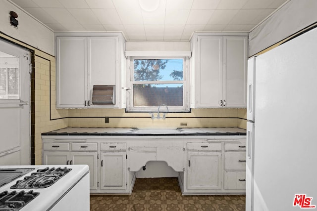 kitchen featuring backsplash, white cabinetry, and white appliances