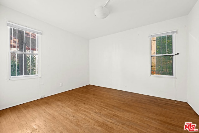 spare room with plenty of natural light and hardwood / wood-style flooring