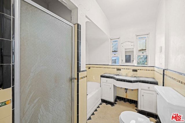 bathroom featuring shower with separate bathtub, toilet, tile walls, and tile patterned floors