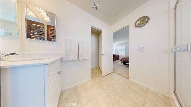 bathroom featuring a shower with door and vanity