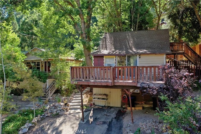 back of house featuring a wooden deck and a patio