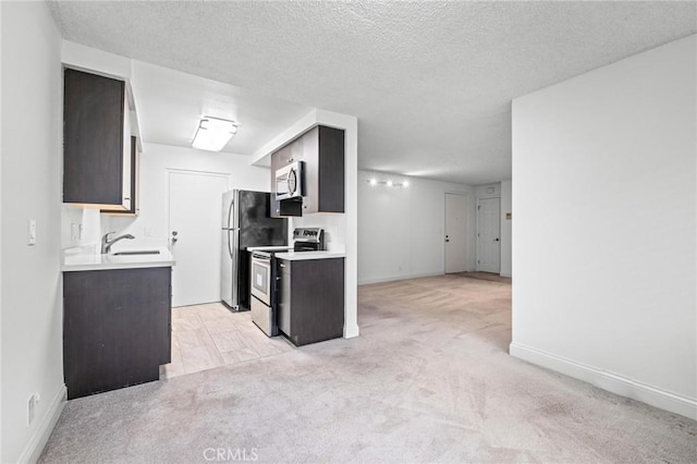 kitchen featuring a textured ceiling, light carpet, and appliances with stainless steel finishes