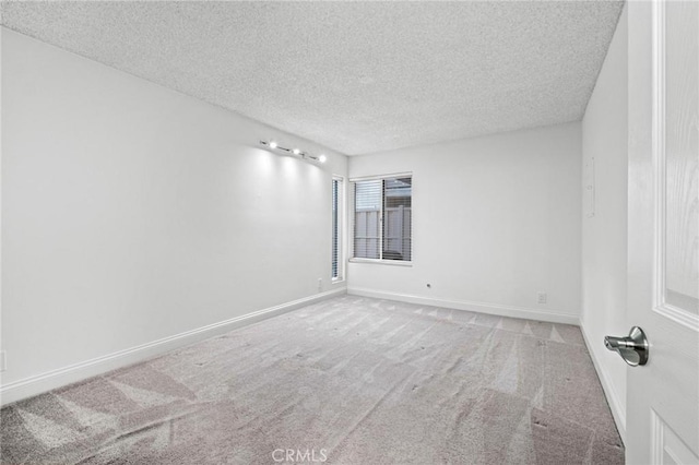 unfurnished room featuring carpet flooring and a textured ceiling