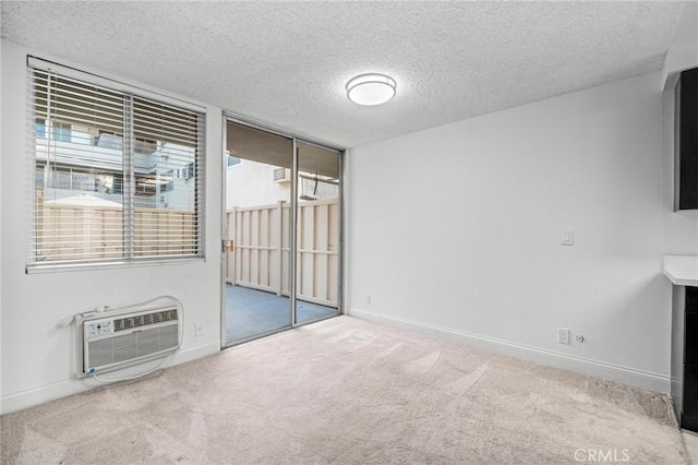 unfurnished room with a textured ceiling, light carpet, and a wall mounted AC