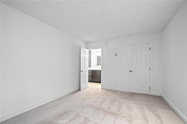 unfurnished room featuring light colored carpet and a textured ceiling