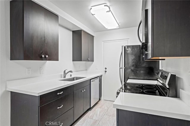 kitchen with dark brown cabinetry, stainless steel appliances, and sink