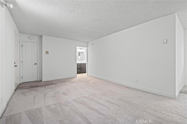 carpeted spare room featuring a textured ceiling