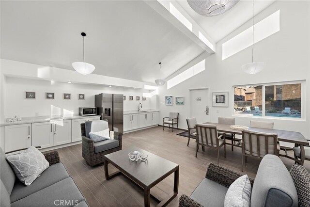 living room with hardwood / wood-style floors, sink, and high vaulted ceiling