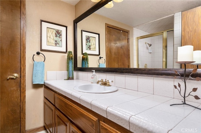 bathroom with a shower with door and vanity