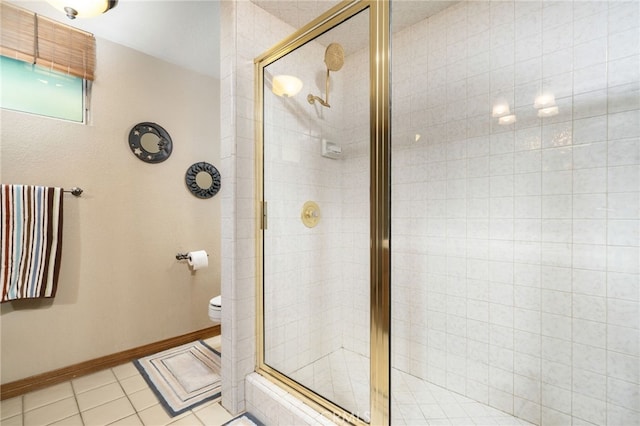 bathroom featuring toilet, tile patterned floors, and a shower with shower door