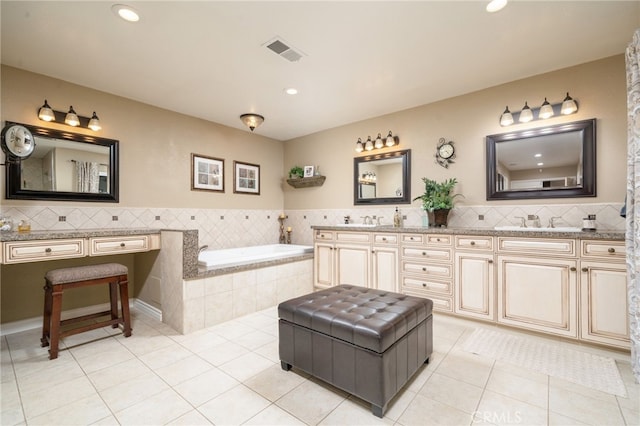 bathroom featuring tiled bath, tile patterned flooring, and vanity