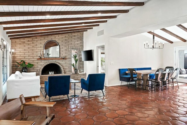 living room featuring vaulted ceiling with beams, dark tile patterned floors, a fireplace, and a chandelier