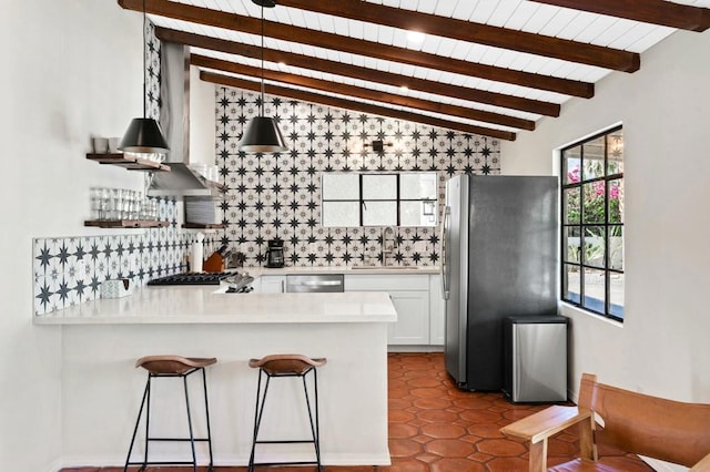 kitchen with pendant lighting, lofted ceiling with beams, sink, white cabinetry, and stainless steel appliances