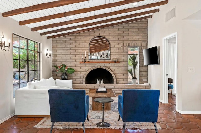 living room featuring beamed ceiling, dark tile patterned flooring, a fireplace, and wooden ceiling