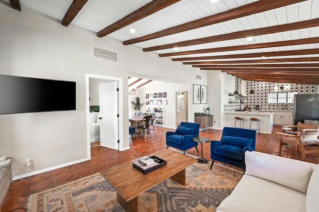 living room featuring lofted ceiling with beams and dark tile patterned floors