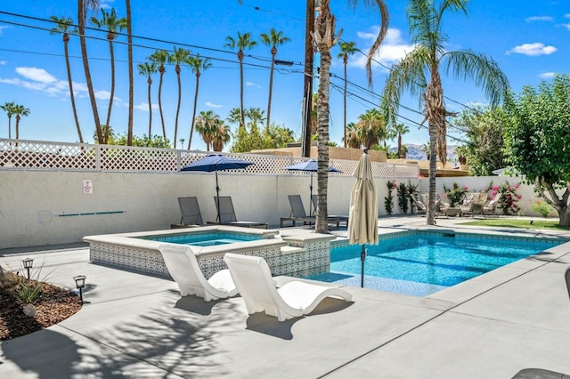 view of swimming pool featuring a patio area and an in ground hot tub