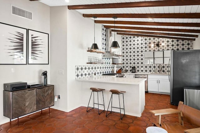 kitchen with stainless steel appliances, sink, pendant lighting, white cabinets, and a breakfast bar area