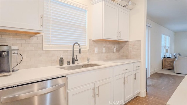 kitchen with white cabinetry, dishwasher, sink, and tasteful backsplash