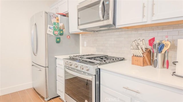 kitchen with white cabinetry, stainless steel appliances, light wood-type flooring, and backsplash