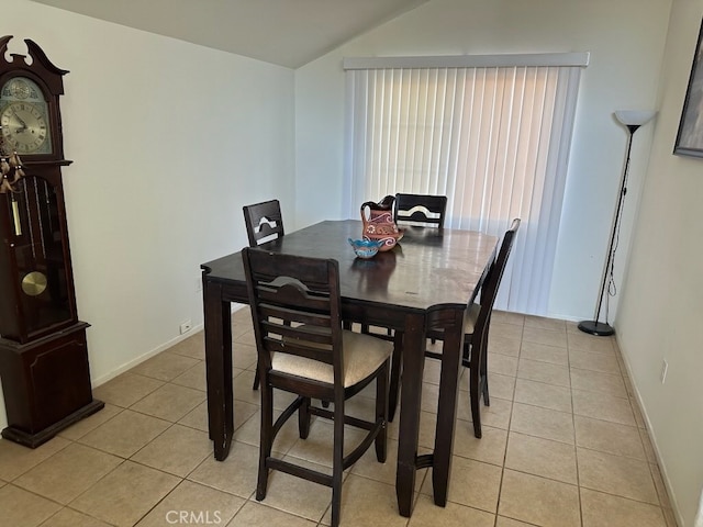 dining area with vaulted ceiling and light tile patterned flooring