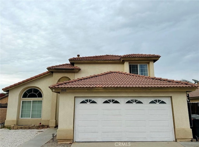 mediterranean / spanish-style home with a garage