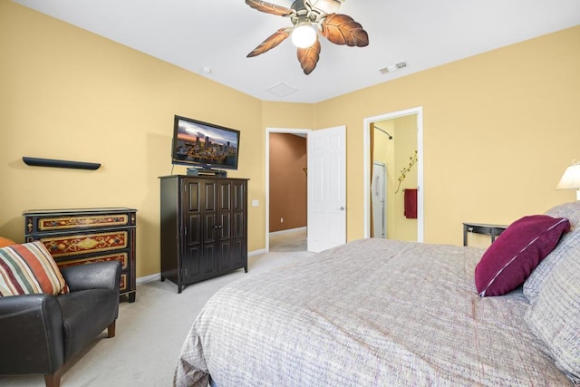 bedroom featuring ceiling fan, light carpet, and ensuite bath