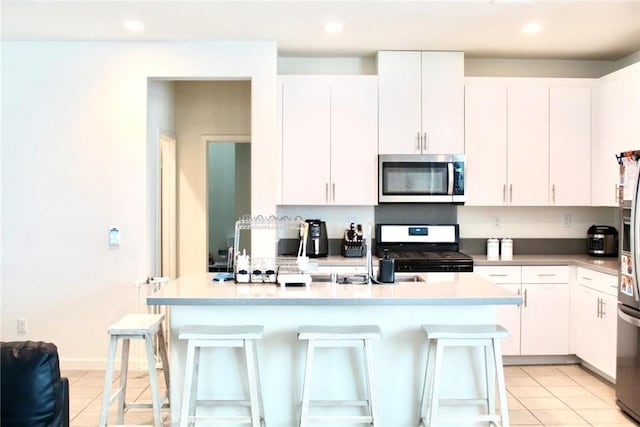 kitchen with white cabinets, a breakfast bar, and appliances with stainless steel finishes