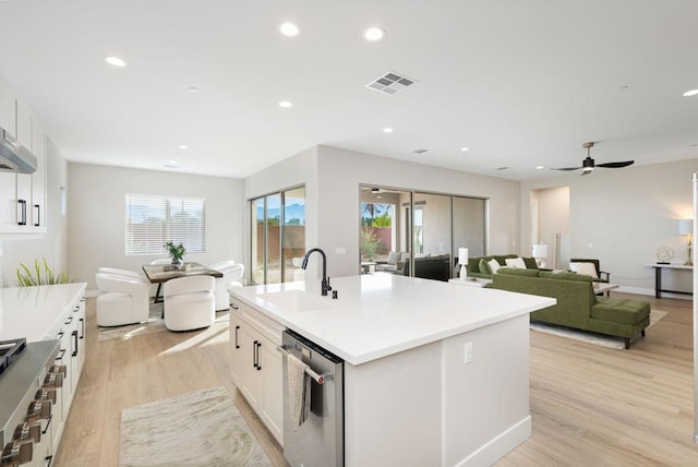 kitchen with white cabinets, sink, a kitchen island with sink, light wood-type flooring, and ceiling fan